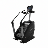  Full profile view of a Life Fitness PowerMill commercial stair climber featuring a dark gray frame, bullhorn handlebars, tiered moving steps, and a large tablet-style console screen.