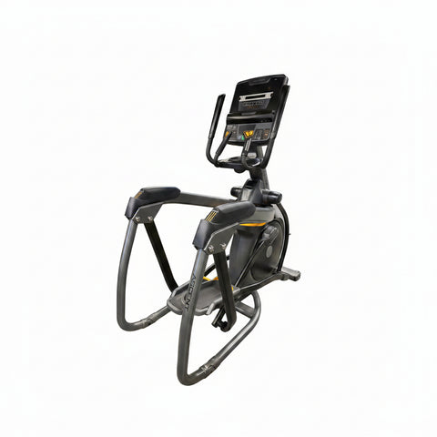  Front-angle view of a Matrix Performance Lower Body Ascent Trainer fitness machine showcasing its track-free suspension design, stationary handlebars, and oversized foot pedals on a dark commercial gym floor.