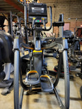  Side view profile of a grey Matrix commercial lower body fitness machine, highlighting the low step-on height and wheel-free pedal linkage.