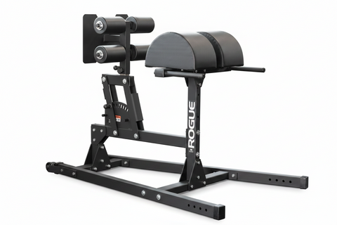  The Rogue Abram GHD 2.0 positioned next to weight racks inside a compact home garage gym