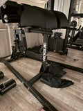 Three-quarter studio view of the Rogue Abram 2.0 Glute-Ham Developer highlighting the heavy-duty 2x3 inch 11-gauge steel frame and textured footplate.